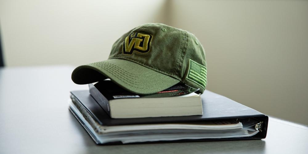Green Grand Valley Hat on top of books